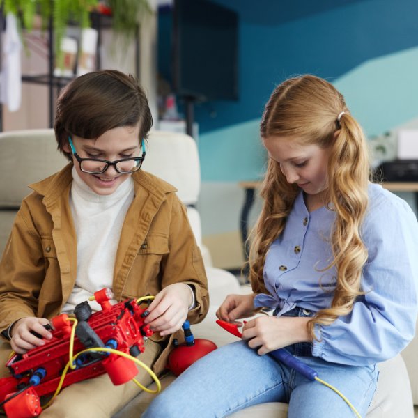 Two kids operating a robot