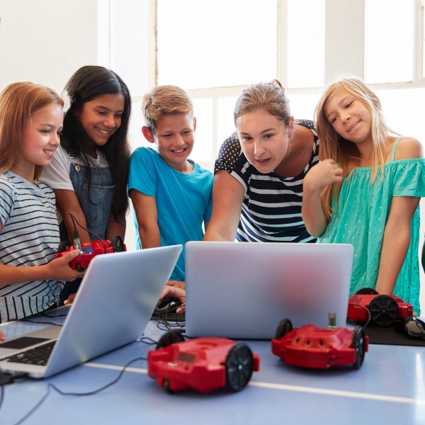 Kids coding their robots using laptops